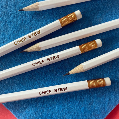 Image of a white pencil with 'chief stew' embossed on it in gold lettering