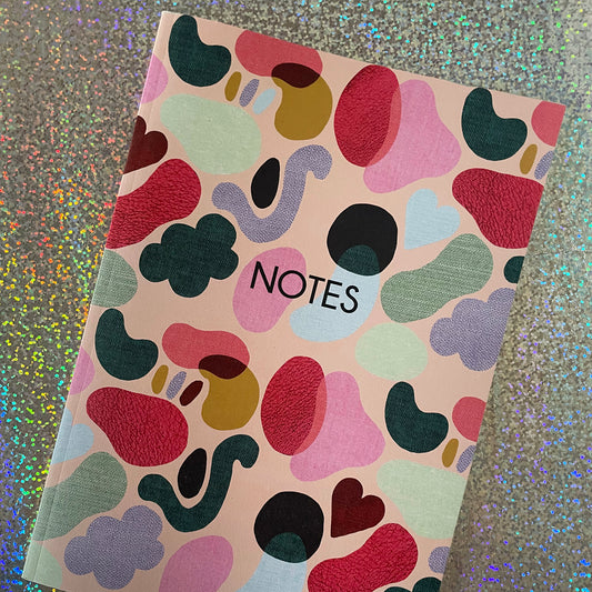 Image of a colourful notebook with a textured shapes pattern in bright colours and the word notes in black. 
