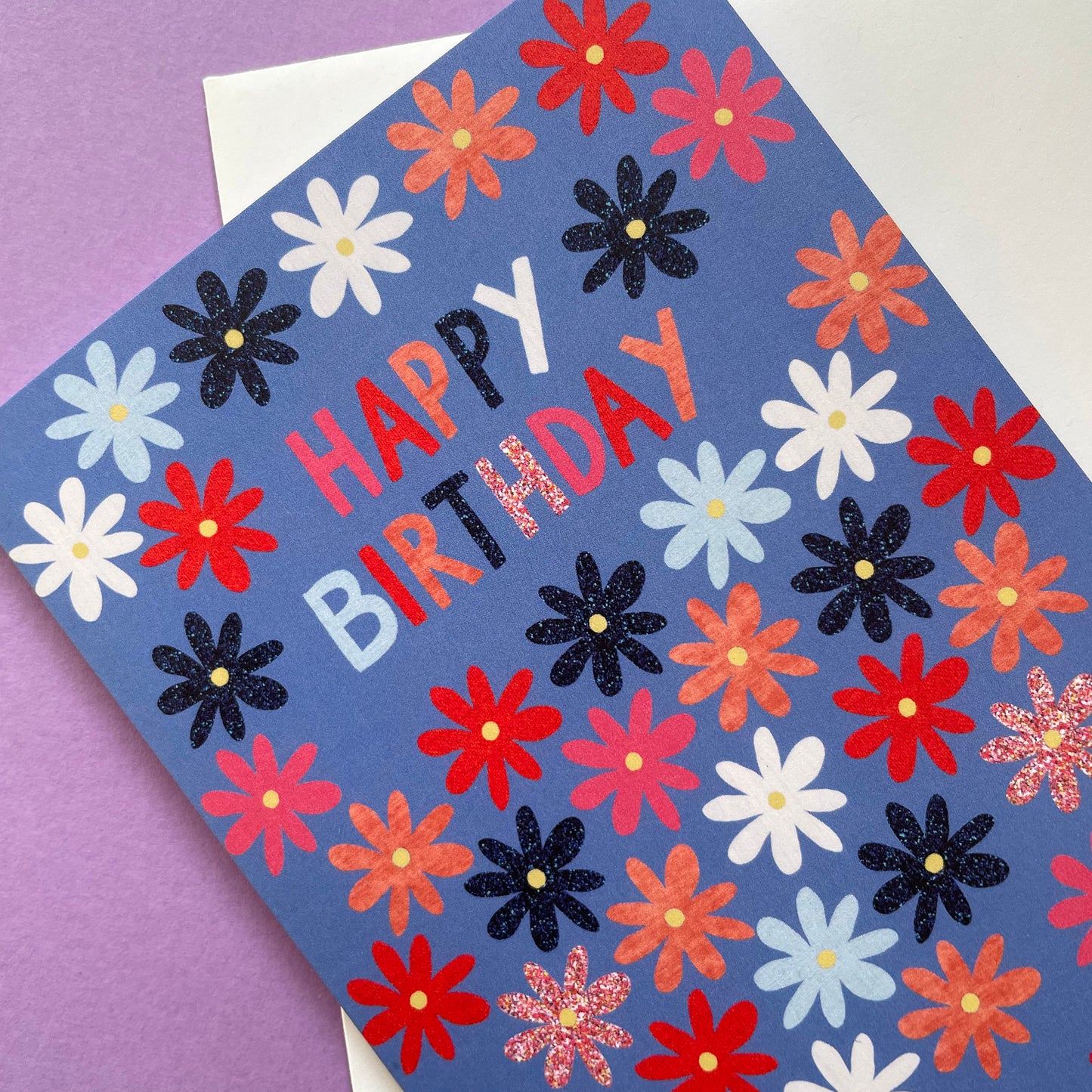 Colourful birthday card with flowers and 'Happy Birthday' text on a purple background