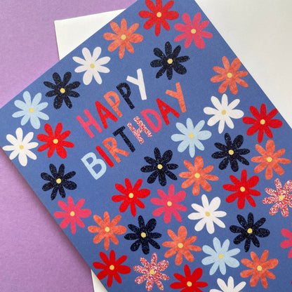 Colourful birthday card with flowers and 'Happy Birthday' text on a purple background