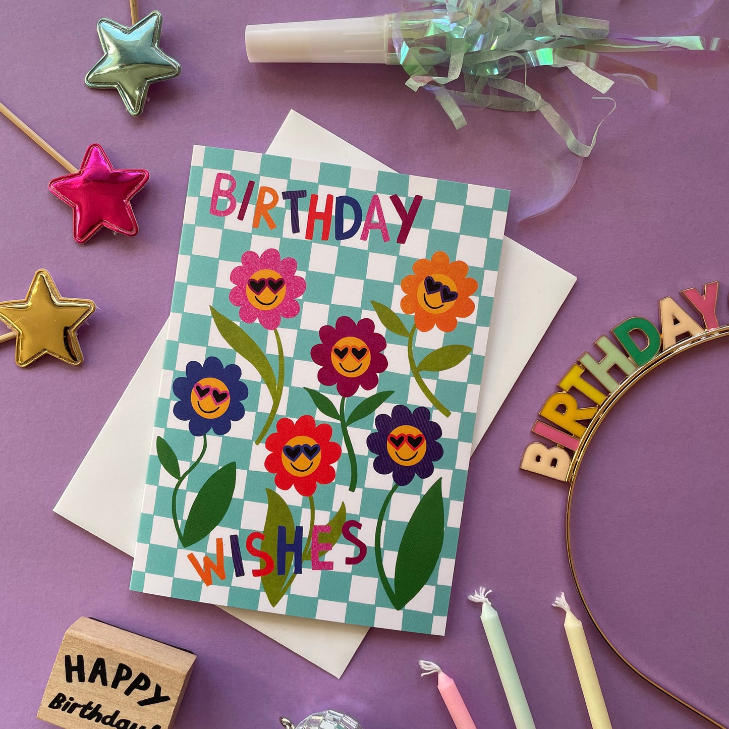 Birthday card with floral design and celebratory items on a purple background