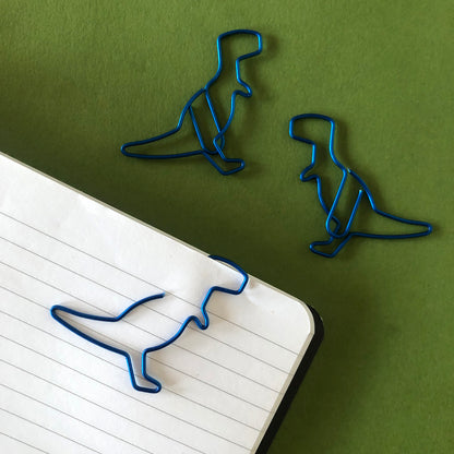Image shows a set of metallic blue dinosaur shaped paperclips.