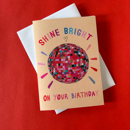 Birthday card with disco ball illustration and text on a red background
