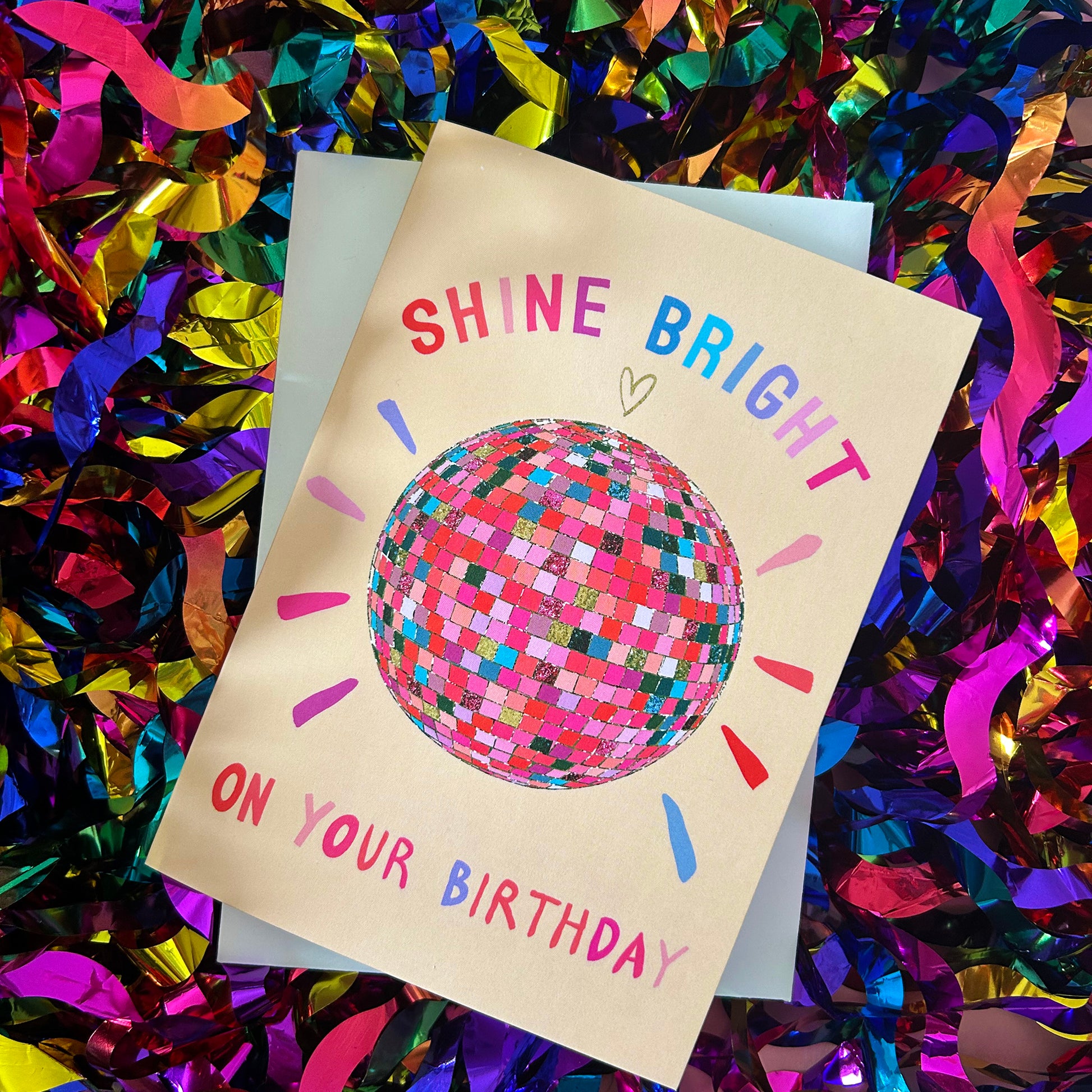 Birthday card with colourful text and disco ball illustration on a confetti background