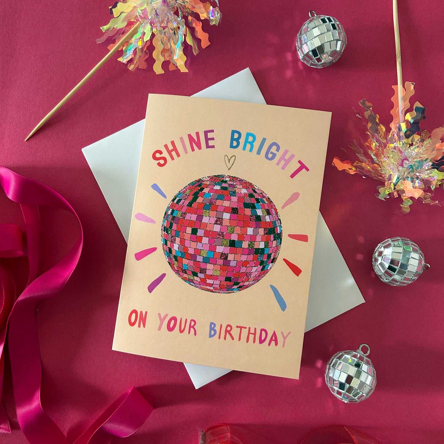 Birthday card with disco ball design on a red background with party decorations