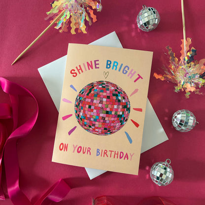 Birthday card with disco ball design on a red background with party decorations