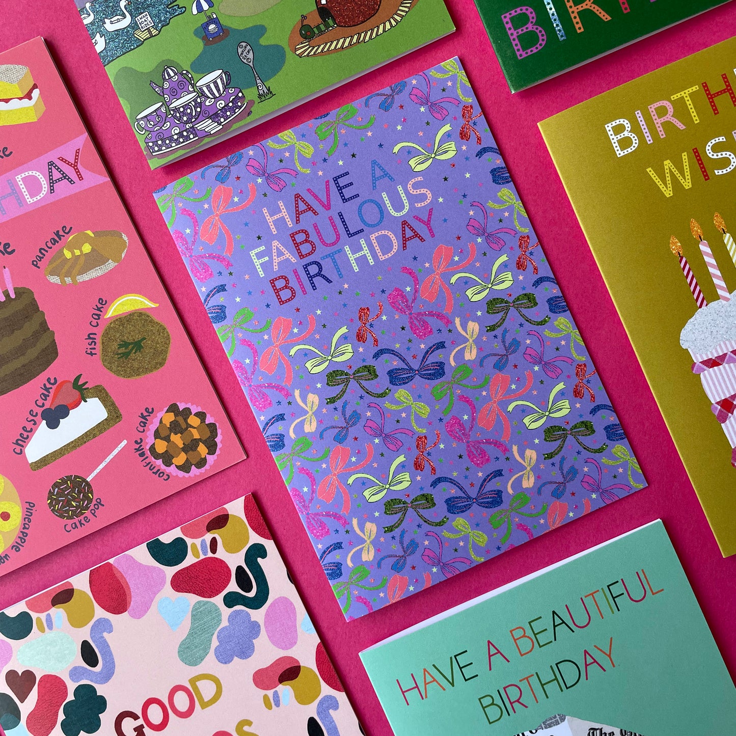 Image shows a lilac birthday card with neon and sparkly bow illustrations and a cloud with multicoloured wording that reads 'Have a fabulous birthday"