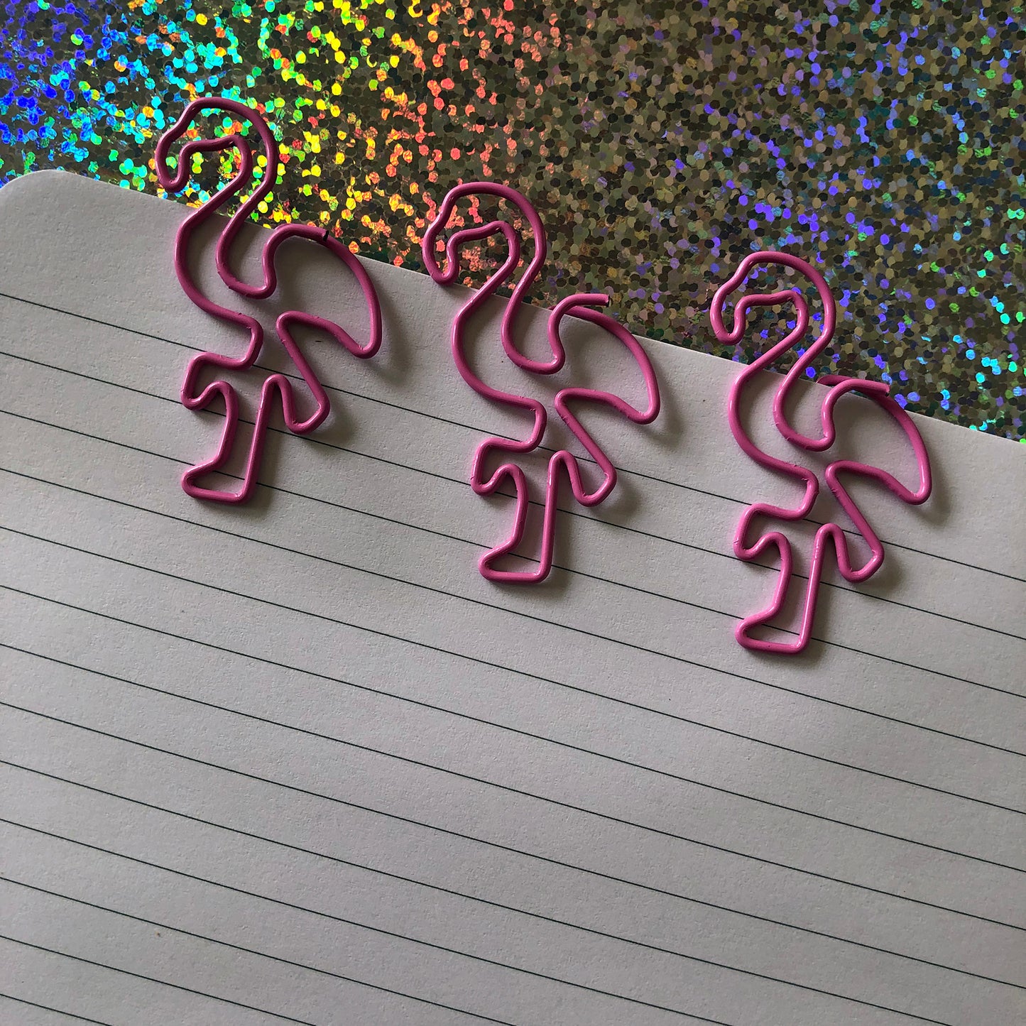 Image shows a set of pink flamingo shaped paperclips.