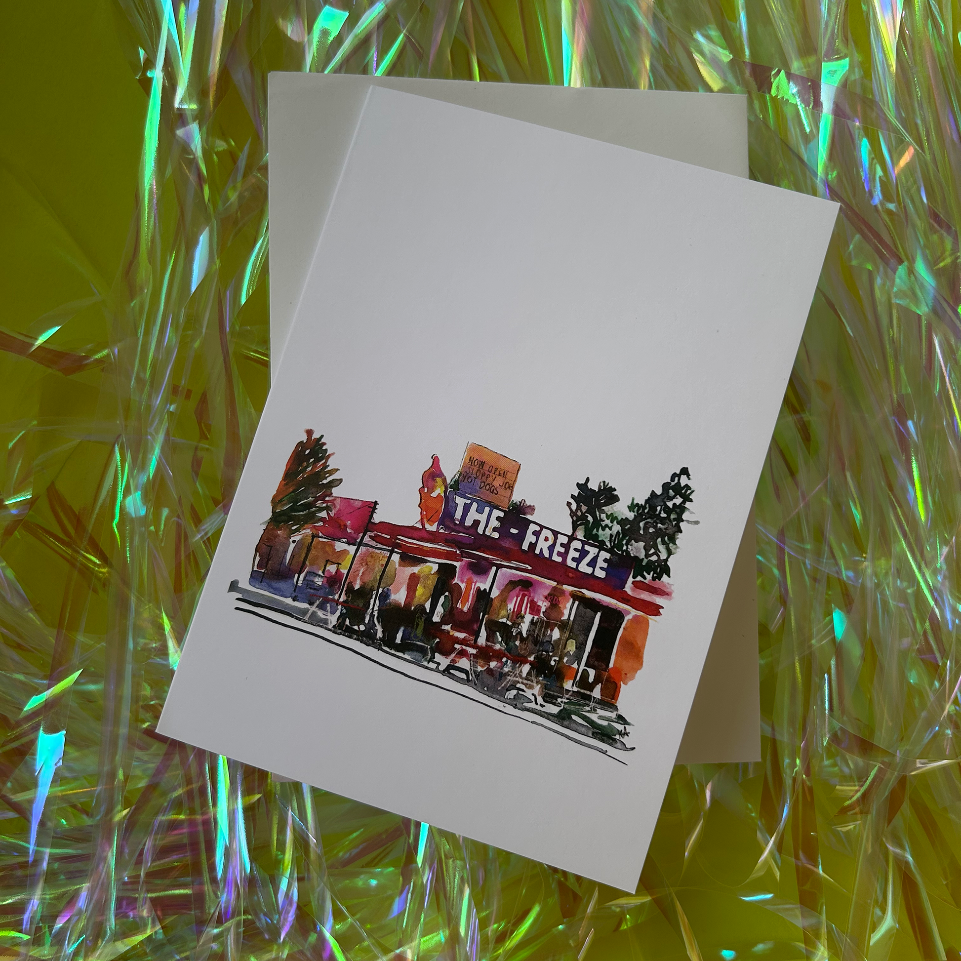 Greeting card with 'The Freeze' illustration on a reflective surface