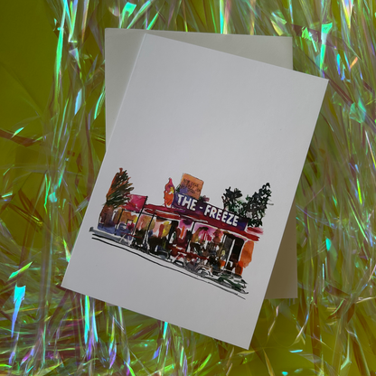 Greeting card with 'The Freeze' illustration on a reflective surface