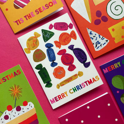 Colourful Christmas cards with sweetie designs and text on a pink background