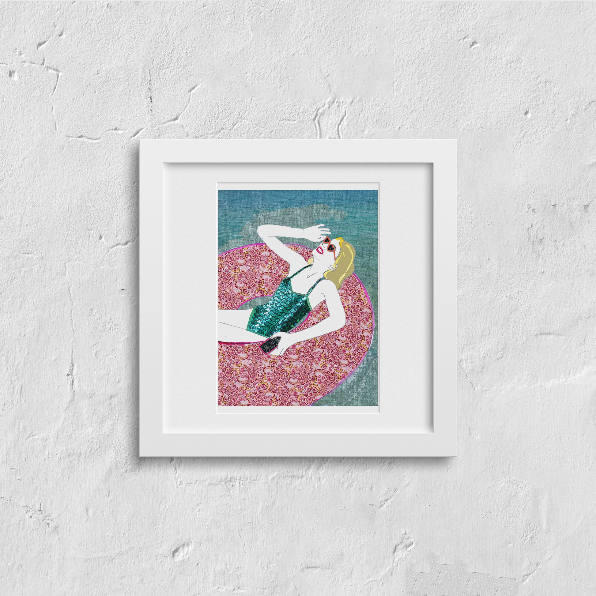 Framed artwork on a white wall, illustration of a woman relaxing in a pool ring in the summer