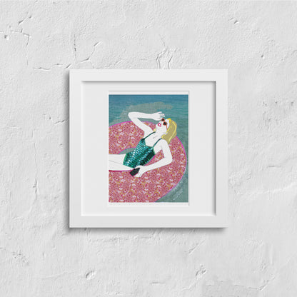 Framed artwork on a white wall, illustration of a woman relaxing in a pool ring in the summer