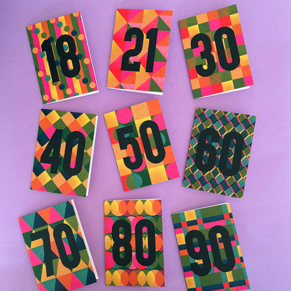 Nine colourful patterned cards arranged in a grid on a lavender background, each printed with a large black number from 18 to 90.