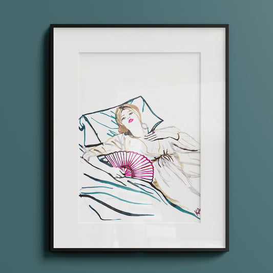 Image of a framed piece of art.  An ink illustration of a woman lying on a bed with a fan. Hand drawn in drawing inks.