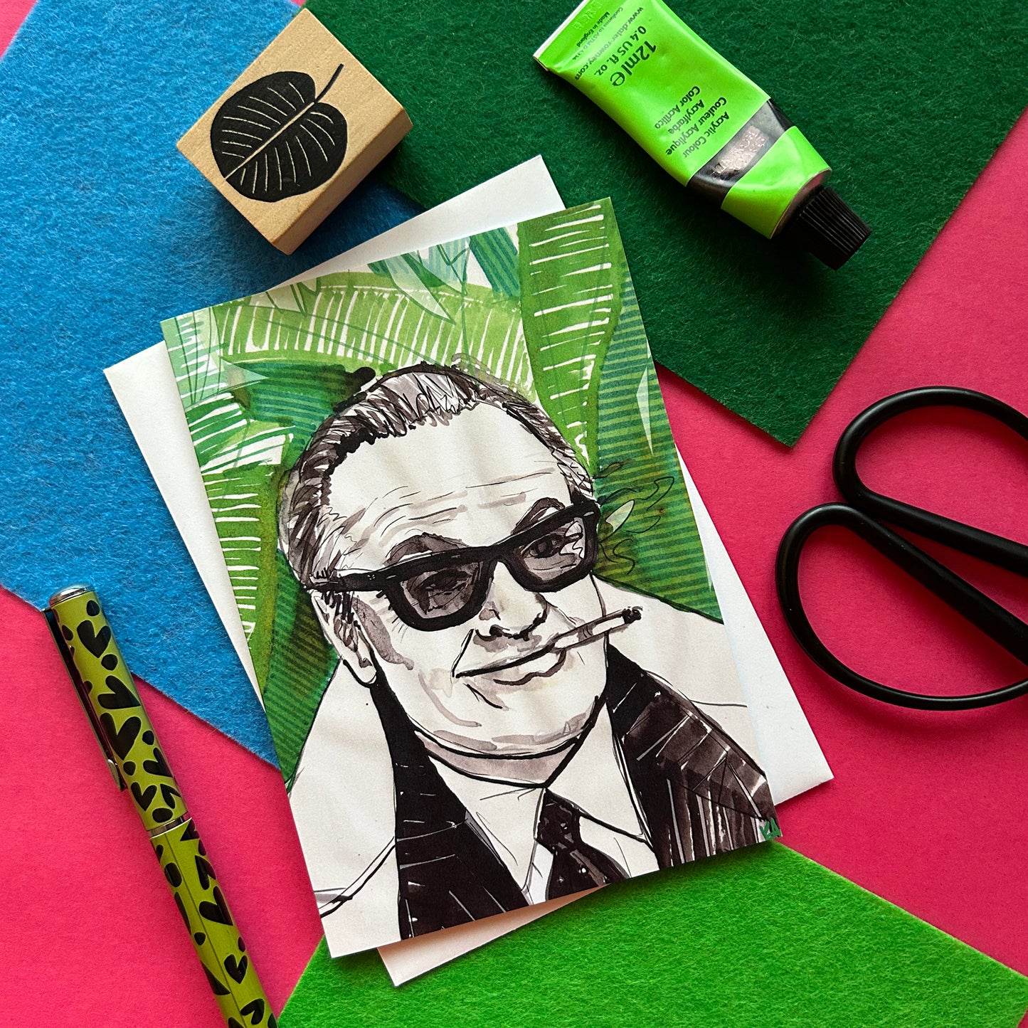 Artistic portrait of a person with sunglasses on a colorful background with art supplies.