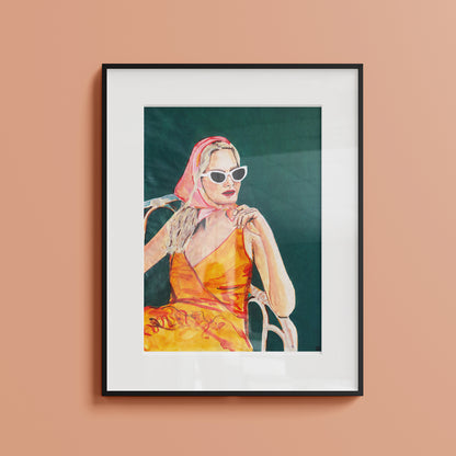 Image of a framed portrait of a woman in an orange dress and pink headscarf. 