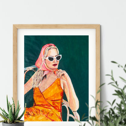 Image of a framed portrait of a woman in an orange dress and pink headscarf. 