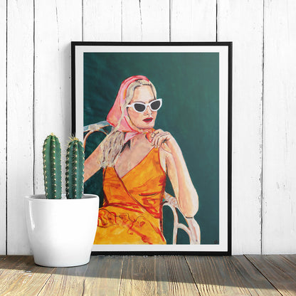 Image of a framed portrait of a woman in an orange dress and pink headscarf. 