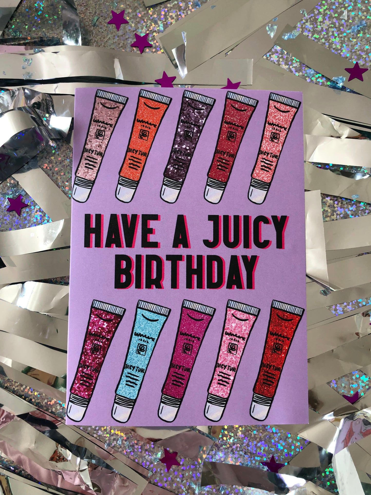 Lilac Birthday Card featuring an illustration of noughties cult beauty product juicy tubes lip gloss and the message 'have a juicy birthday'