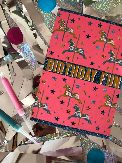 Bright and fun birthday card featuring a carousel horse design on a silver and holographic background