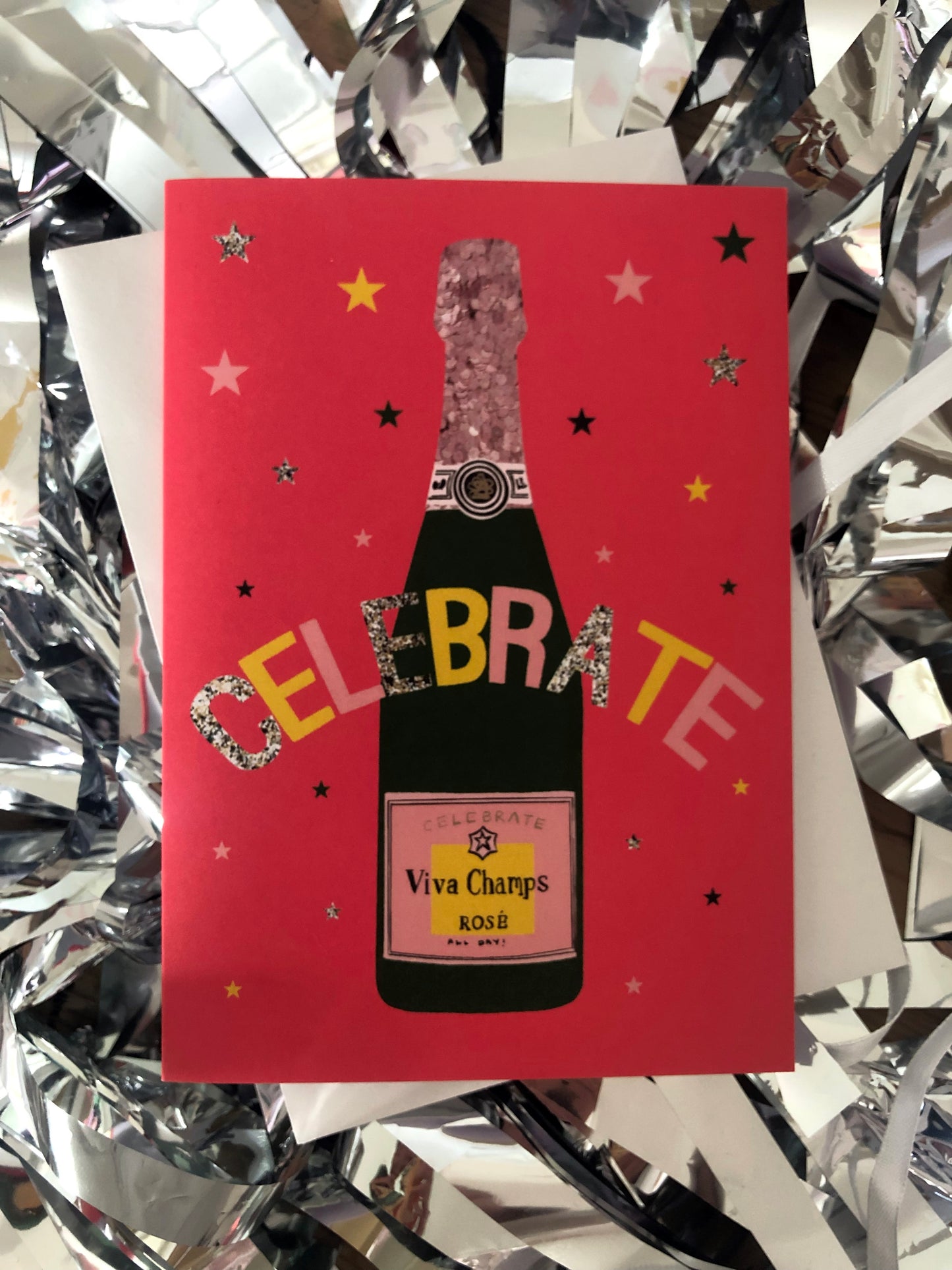 Bright red celebration card featuring a champagne bottle and stars