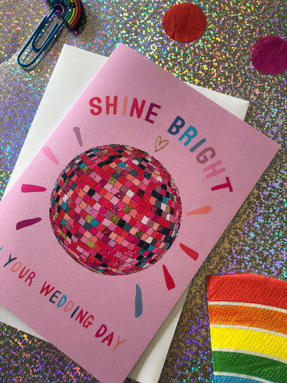 Pink wedding card featuring a glittery rainbow disco ball.
