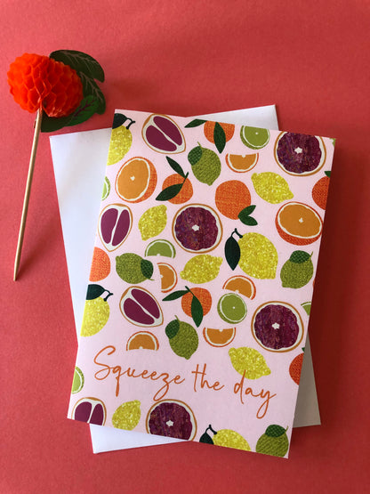 Everyday greetings card that says 'squeeze the day' and features a fun pattern of lemons, oranges, tangerines and grapefruit