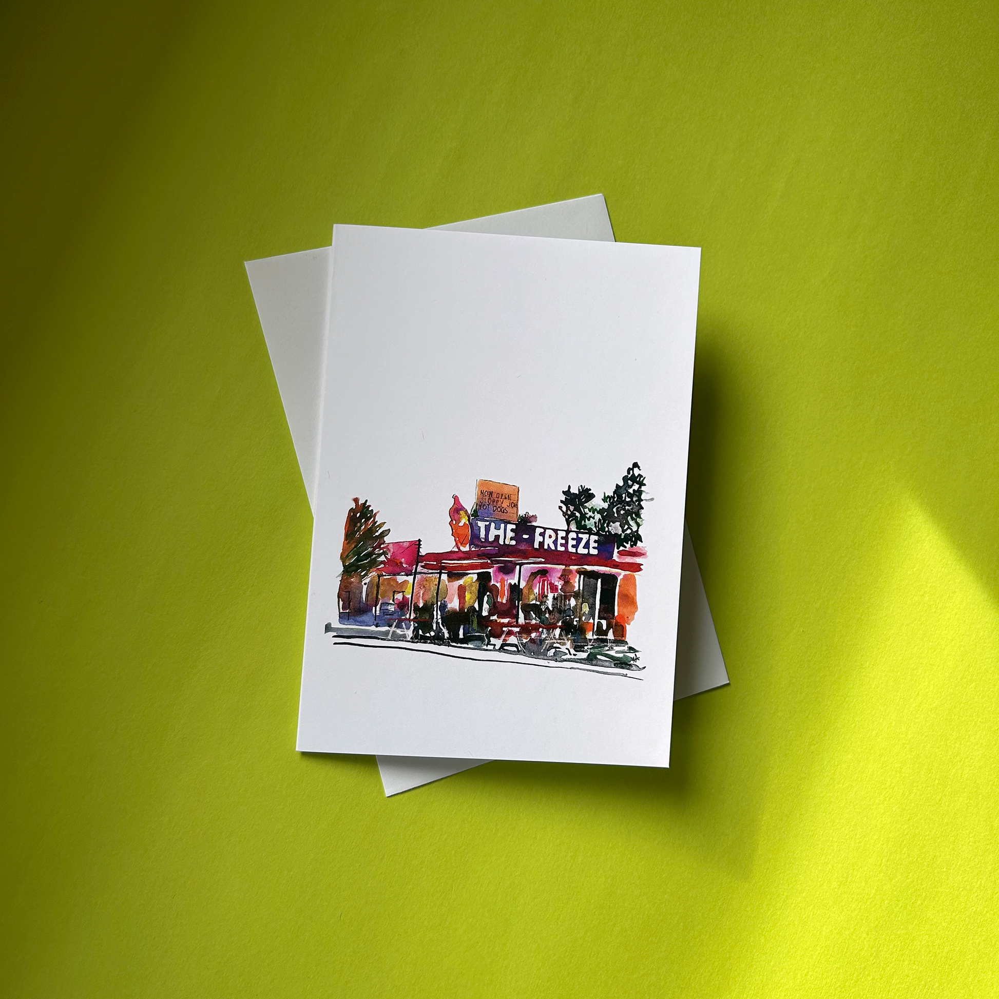 Greeting card with 'The Freeze' store illustration on a green background