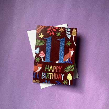 Birthday card with number 11 and fox design on a purple background