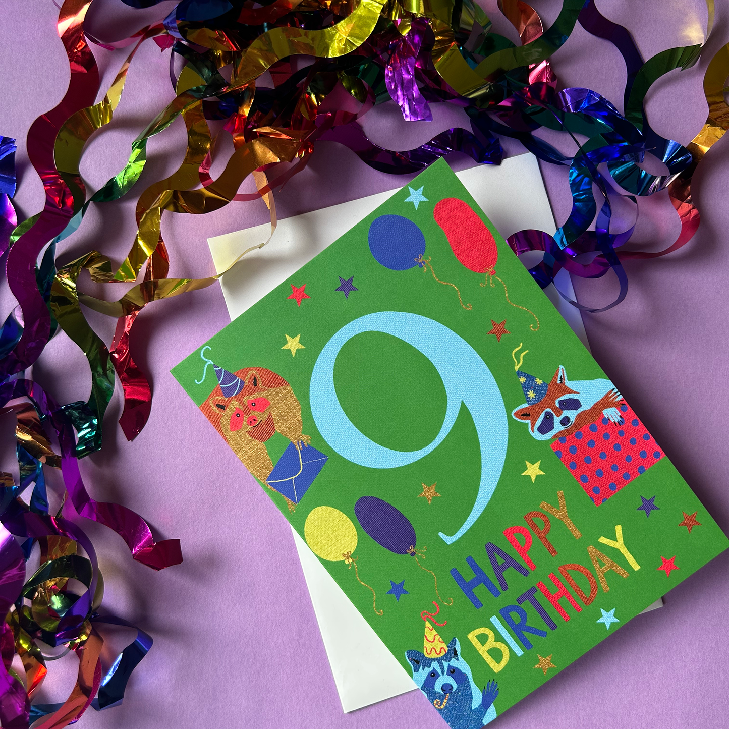 Colorful birthday card with number 9 and party decorations on a purple background