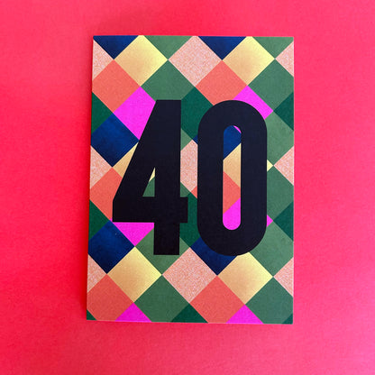 A bright greeting card with a colourful geometric diamond pattern and the number '40' in bold black text, displayed on a solid pink background.