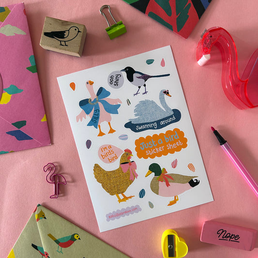 Sheet of bird stickers with decorative items on a pink surface