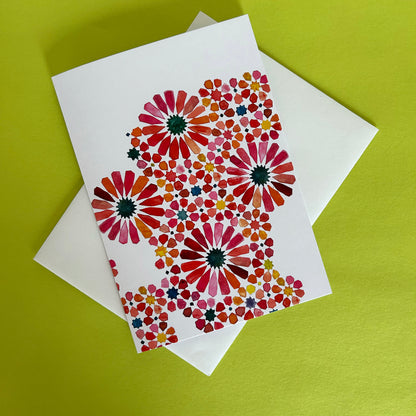 Greeting card with floral Moroccan pattern design on a white envelope against a green background