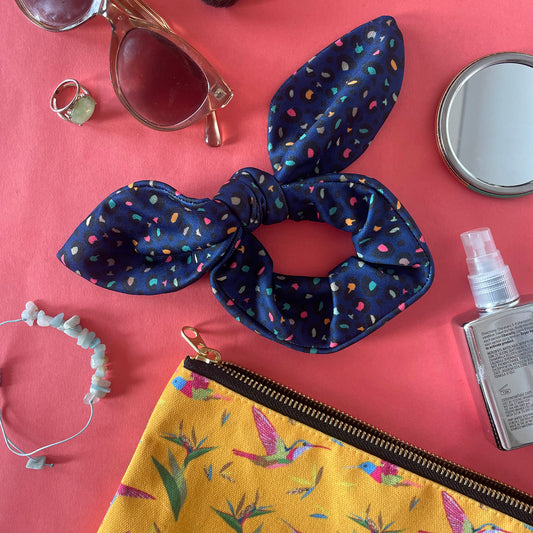 Image shows a handmade midnight blue leopard print hair scrunchie with a bow.