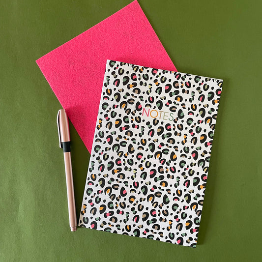 Image of a leopard print A5 size notebook in a cream colour with pops of neon. 