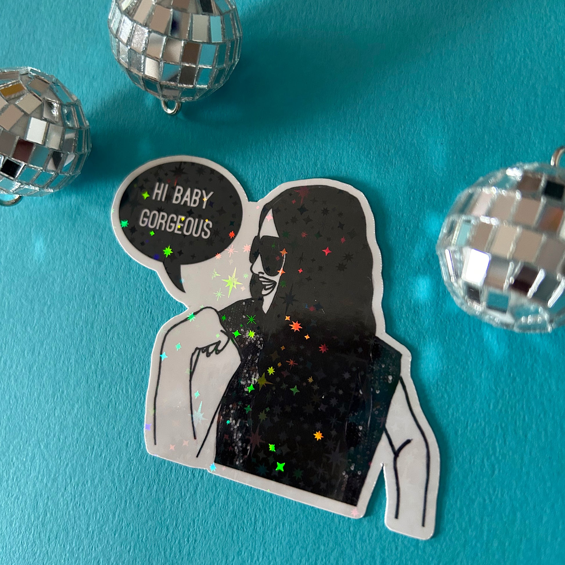 Sticker of Lisa Barlow saying 'Hi Baby Gorgeous', surrounded by disco balls on a blue background.