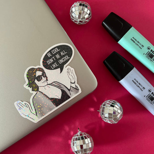 Sticker with a woman and speech bubble on a reflective surface with disco balls and markers.
