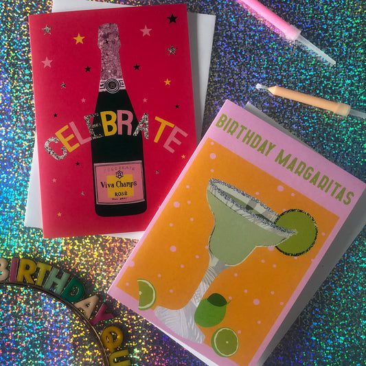 Image shows a yellow and pink coloured  birthday card with the greeting 'Birthday Margaritas' and a lime green cocktail with limes and a glitter salt rim.