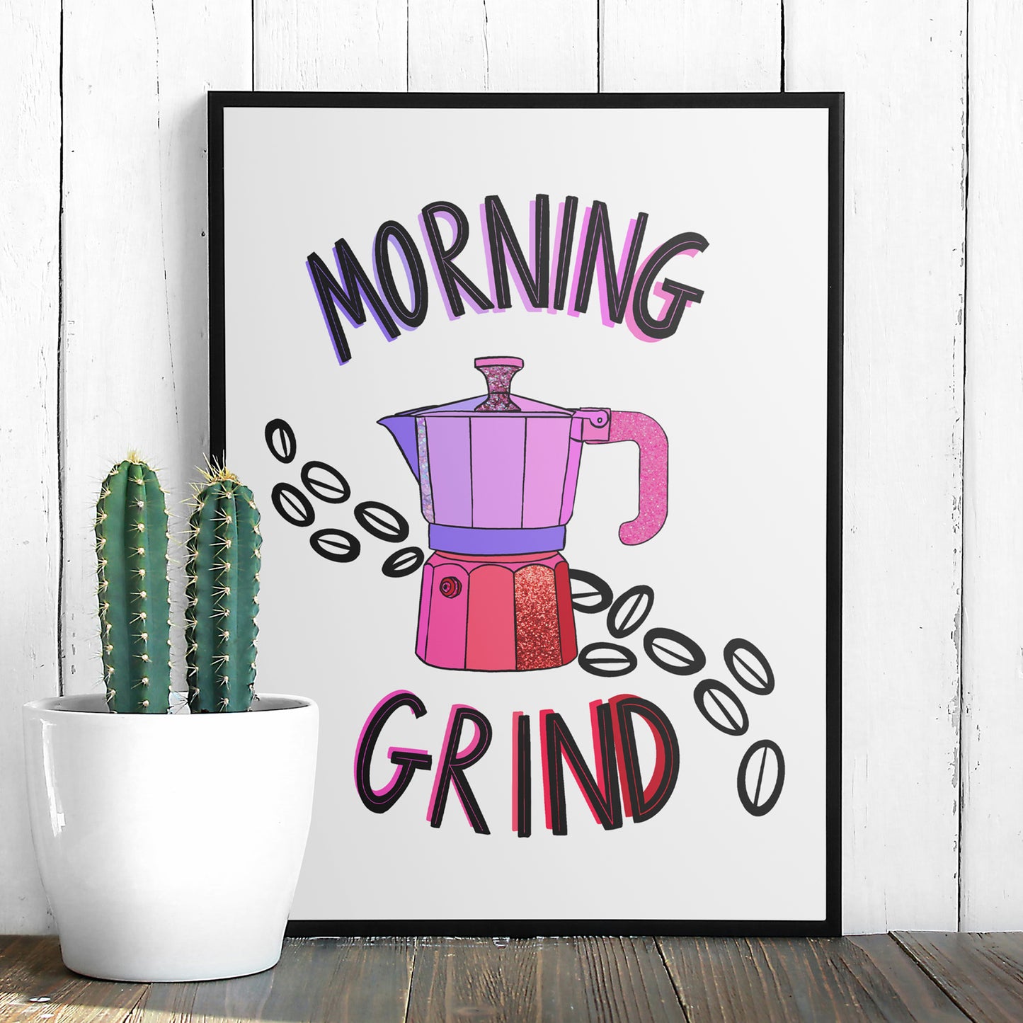 Image shows a framed illustration of a stovetop espresso maker in shades of pink and purple with ink drawn coffee beans behind it. Modern graphic lettering reads Morning Grind. 