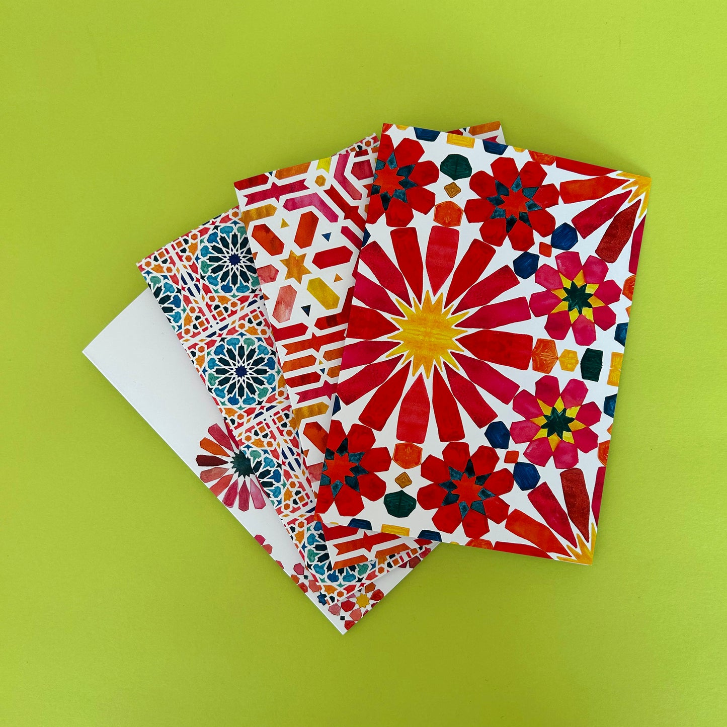 Colorful Moroccan inspired patterned note cards on a green background