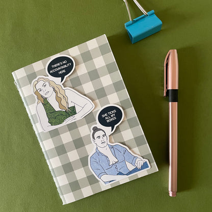 Image of a notebook with 2 illustrated stickers featuring expert Mel and a typical groom from Married at First Sight Australia