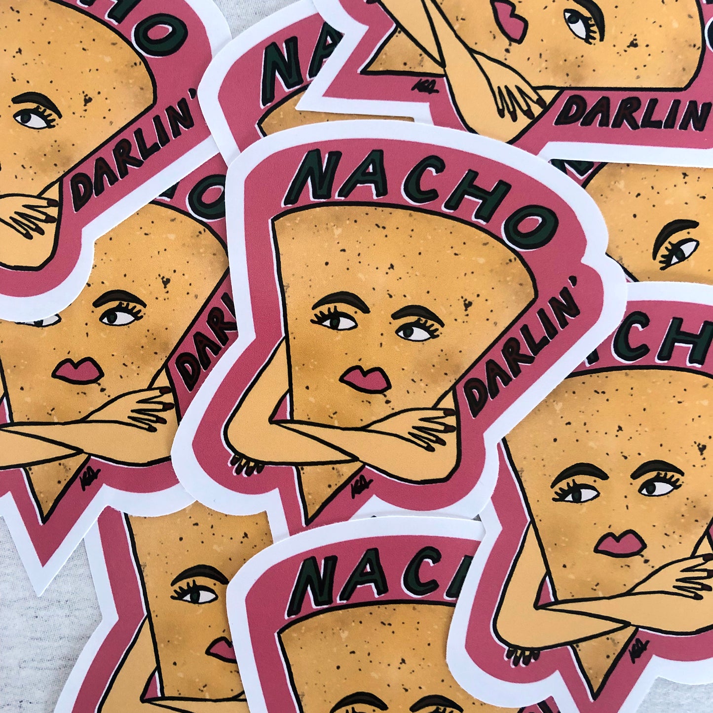 Image shows a vinyl sticker featuring an illustration of a nacho with her arms crossed and he wording 'Nacho Darlin'