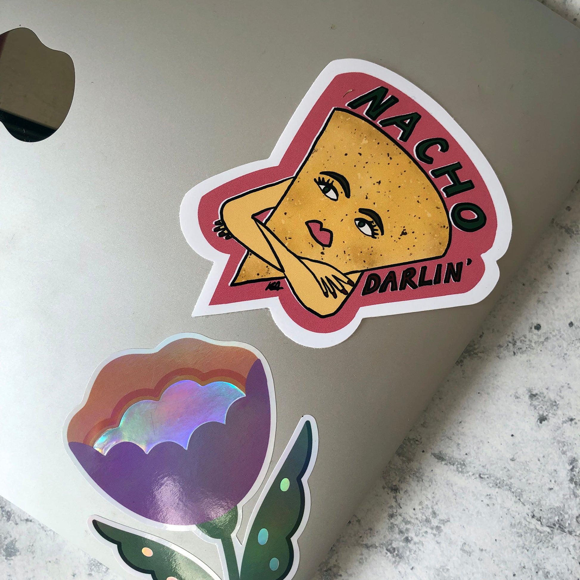 Image shows a vinyl sticker featuring an illustration of a nacho with her arms crossed and he wording 'Nacho Darlin'