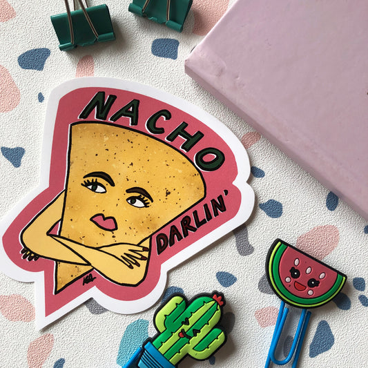 Image shows a vinyl sticker featuring an illustration of a nacho with her arms crossed and he wording 'Nacho Darlin'