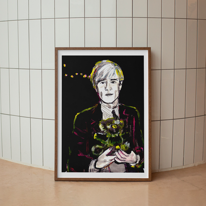 Image shows a framed portrait of artist Andy Warhol holding a teddy bear. The artwork is painted in black and white with  neon pink and yellow highlights.