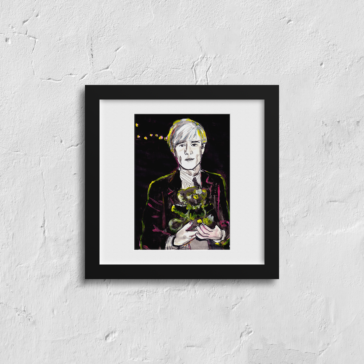 Image shows a framed portrait of artist Andy Warhol holding a teddy bear. The artwork is painted in black and white with  neon pink and yellow highlights.