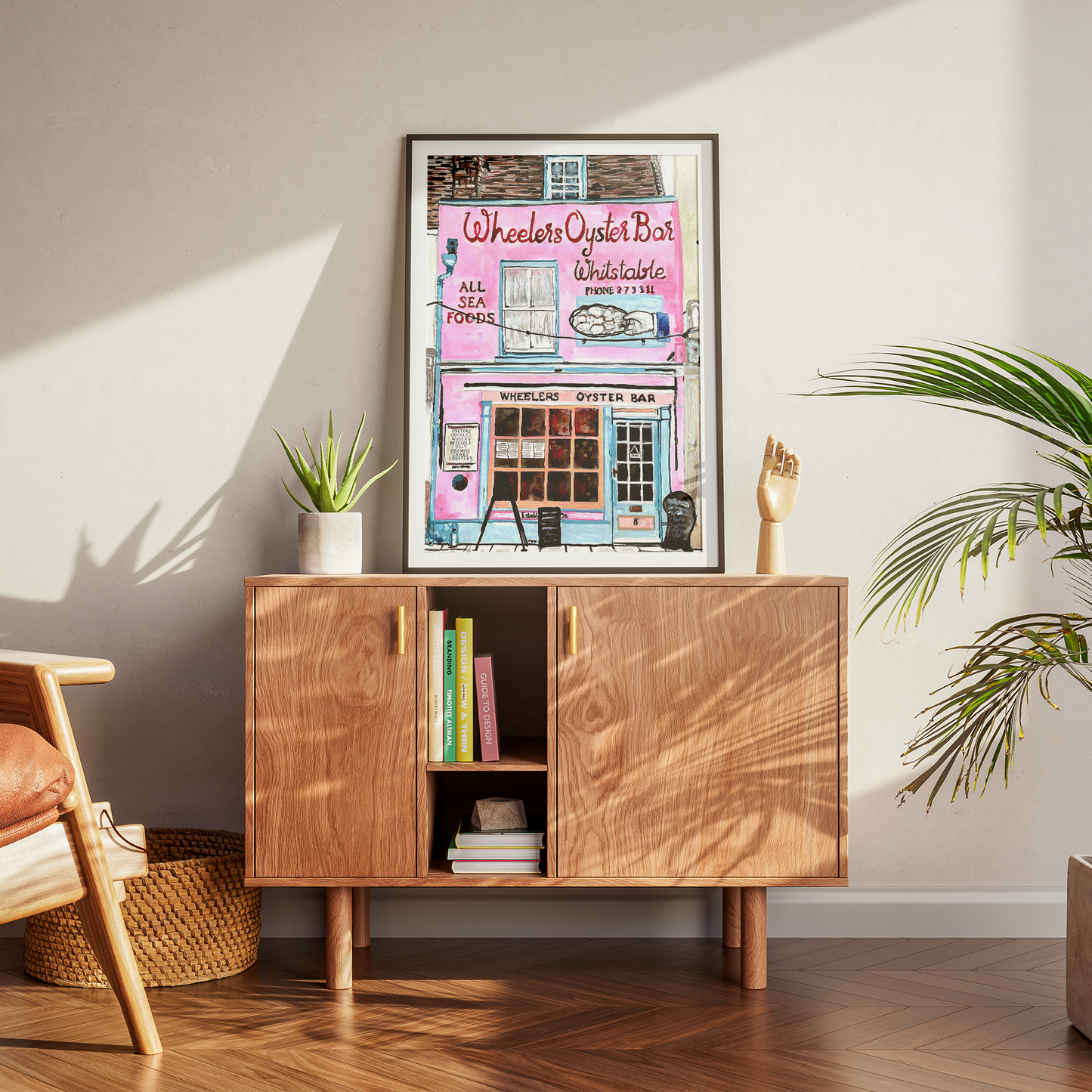 Wooden cabinet with a framed print on a wall in a room with plants and furniture.