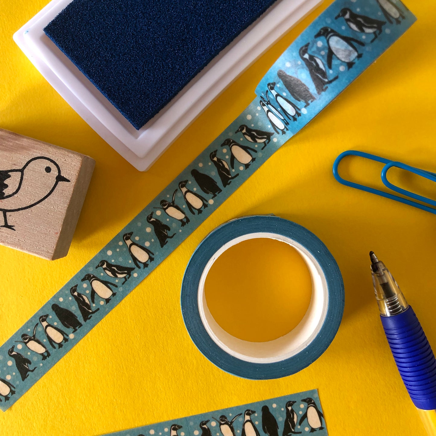 Image shows a blue washi tape with a fun penguin and snowball print
