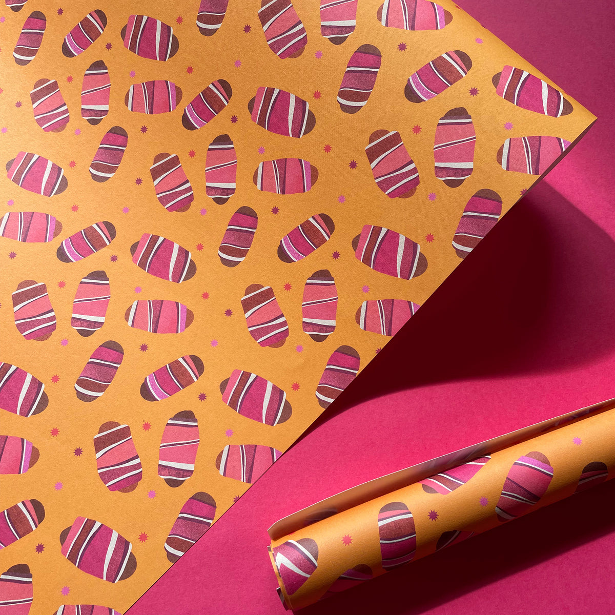 Patterned paper with pink and brown design on a pink background